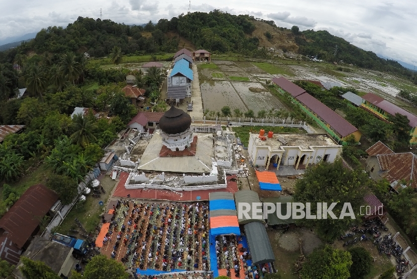 Foto aerial umat muslim menunaikan Shalat Jumat di Masjid Jamik Quba, Pidie Jaya, NAD, Jumat (9/12).