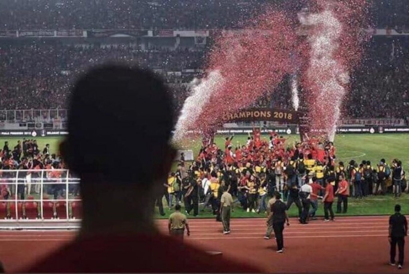 Foto Anies Baswedan di tribun VVIP Stadion Utama Gelora Bung Karno, memandangi keriuhan penyerahan trofi juara Piala Presiden 2018.
