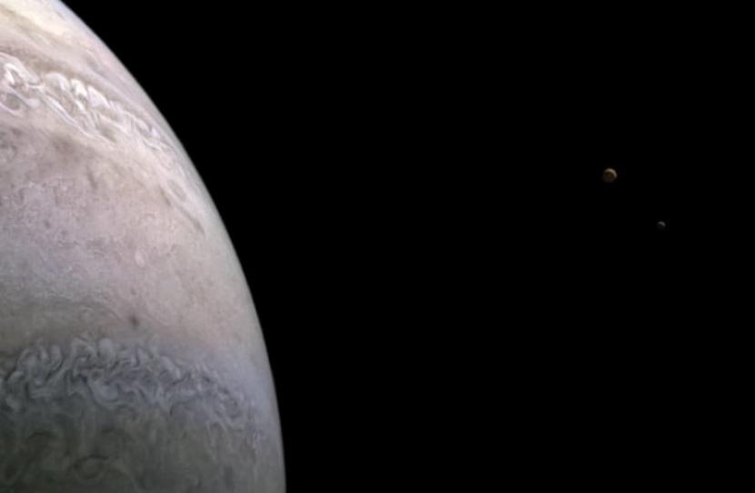 Foto bulan Jupiter, Io (kiri) dan Europa (kanan) yang diambil dengan pesawat Juno.