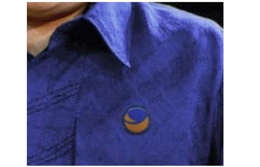 Foto hoaks Menteri BUMN Erick Thohir mengenakan baju batik biru dengan pin Partai NasDem di dada kiri.
