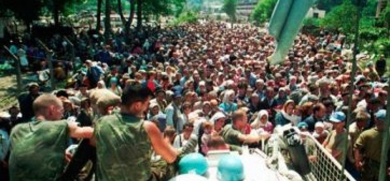 Foto pada 13 Juli 1995, tampak dua tentara Pasukan PBB asal Belanda duduk di atas APC melihat warga Muslim Srebenica berkumpul di desa Potomari sebelum digiring oleh tentara Serbia.