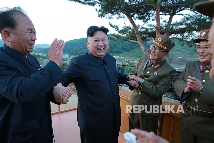 Foto rilis dari pemerintah Korea Utara menggambarkan pemimpin Korea Utara Kim Jong Un merayakan upaya percobaan rudal balistik jarak jauh  Hwasong-12 (Mars-12) diluncurkan militer Korea Utara