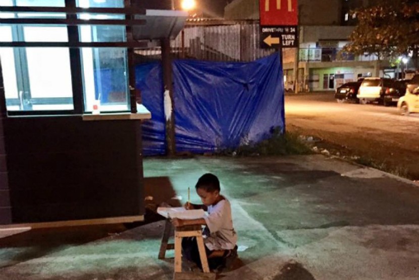 Foto seorang bocah bernama Daniel Cabrera asal Filipina sedang belajar memanfaatkan lampu dari sebuah restoran McDonald.