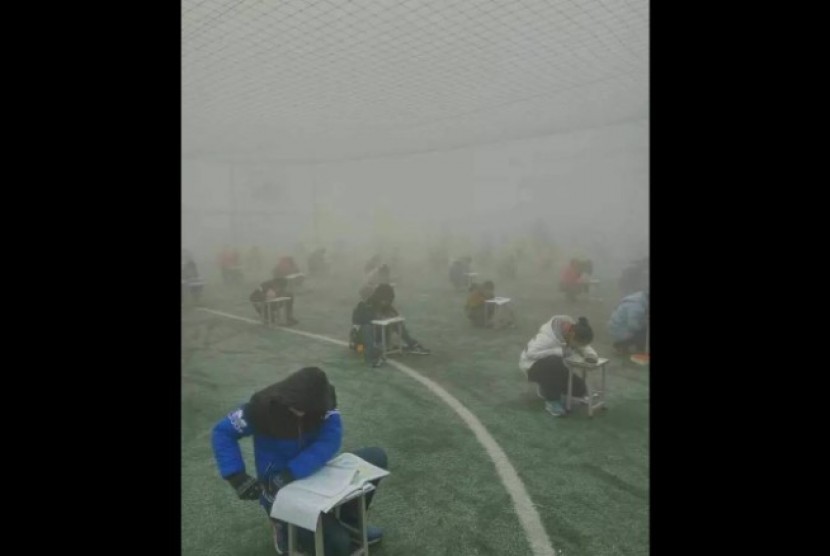 Foto siswa Sekolah Linqi County No. 1 di Provinsi Henan, Cina yang mengerjakan ujian di tengah kabut asap menuai kecaman.