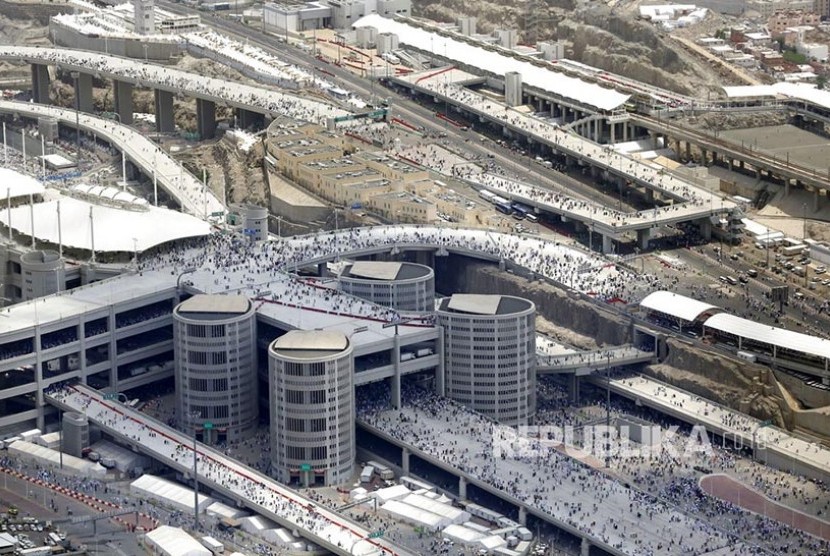Foto udara jalur pejalan kaki dari kota tenda Mina menuju bangunan Jamarat tempat tiga pilar jumrah berada dengan latar Kota Makkah dari kejauhan, Senin (12/8).