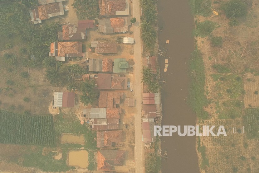 Foto udara kawasan permukiman penduduk yang diselimuti kabut asap di Arang-arang, Kumpeh Ulu, Muarojambi, Jambi, Kamis (15/8/2019). 