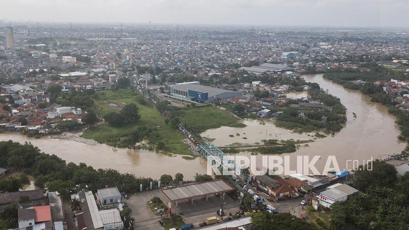 Foto udara kenaikan debit air kali Bekasi di Jawa Barat, Senin (8/2/2021). Menurut data BPBD Bekasi banjir terjadi karena kiriman air dari wilayah Bogor berimbas pada kenaikan debit air kali Bekasi pada pukul 09.00 WIB.
