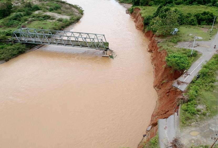 Foto udara kondisi jalan dan jembatan yang amblas di Suwawa Selatan, Kabupaten Bone Bolango, Gorontalo, Rabu (23/3/2022). Jalan dan jembatan penghubung Kecamatan Suwawa dan Suwawa Selatan amblas diterjang aliran air sungai yang meluap pada Sabtu (19/3) lalu.