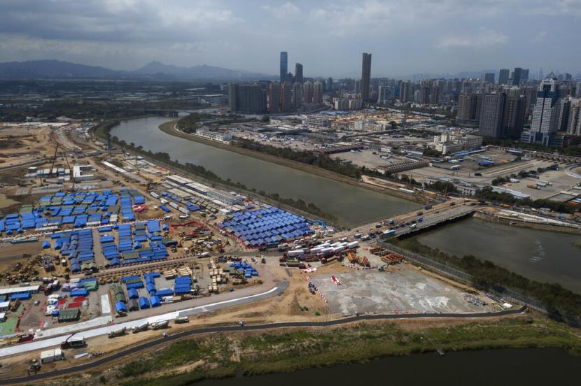 Foto udara menunjukkan fasilitas isolasi Covid-19 dan jembatan sementara yang menghubungkan Shenzen dan Hong Kong, Jumat (11/3/2022). Hong Kong mengubah pusat isolasi Covid-19 menjadi fasilitas karantina cacar monyet.