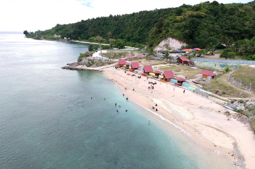 Foto udara objek wisata Pantai Tilalohe di Desa Biluhu Timur, Kabupaten Gorontalo, Gorontalo, Rabu (5/1/2022). Destinasi wisata baru tersebut memiliki pantai berpasir putih, sejumlah penginapan, lokasi selam permukaan (snorkeling) dan bukit untuk berkemah.