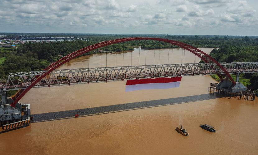  Foto udara sebuah bendera merah putih dibentangkan di Jembatan Kahayan, Palangka Raya, Kalimantan Tengah, Sabtu (6/8/2022). Aksi pembentangan bendera merah putih sepanjang 40 x 8 meter tersebut diikuti oleh TNI, Polri, Basarnas, BPBD, dan relawan ERP yang bertujuan untuk menumbuhkan rasa jiwa nasionalisme kepada generasi muda serta menyemarakkan HUT ke-77 Kemerdekaan Republik Indonesia. 