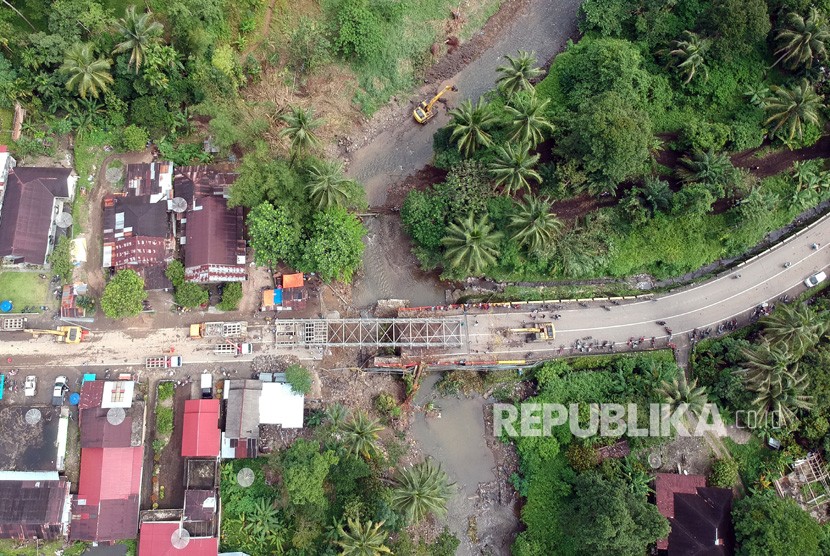 Foto udara sejumlah pekerja memasang panel jembatan sementara di Batang Kalu, Jalur Padang - Pekanbaru, Kayutanam, Padangpariaman, Sumatera Barat, Kamis (13/12/2018). 