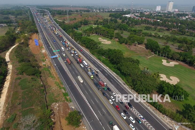 Foto udara suasana antrean kendaraan bermotor yang melintas di titik pertemuan Tol Jakarta-Cikampek elevated II dengan Tol Jakarta-Cikampek KM 48, Karawang Barat, Karawang, Jawa Barat, Senin (23/12/2019).
