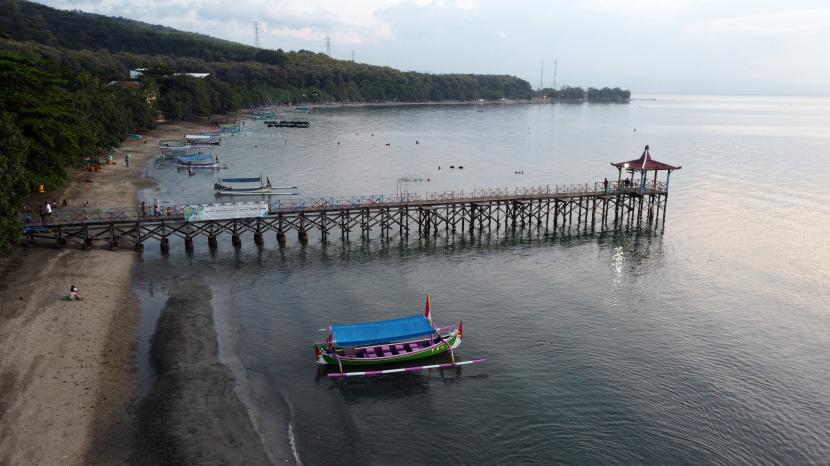 Foto udara suasana Pantai Pasir Putih di Situbondo, Jawa Timur, Jumat (13/5/2022). Pantai yang berada di jalur Pantai Utara (Pantura) tersebut menjadi salah satu wisata bahari unggulan di Kabupaten Situbondo yang menawarkan panorama alam dan keindahan bawah lautnya. 