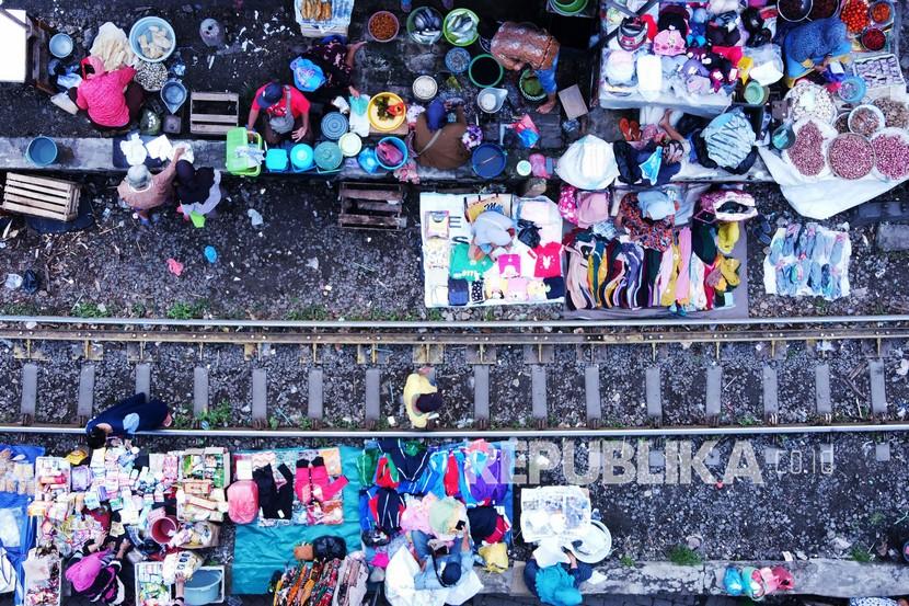 Foto udara suasana pedagang berjualan di pinggir rel kereta api di Surabaya, Jawa Timur, Jumat (4/2/2022). Meskipun berbahaya, para pedagang di wilayah tersebut tetap berjualan di pasar itu setiap pagi. 