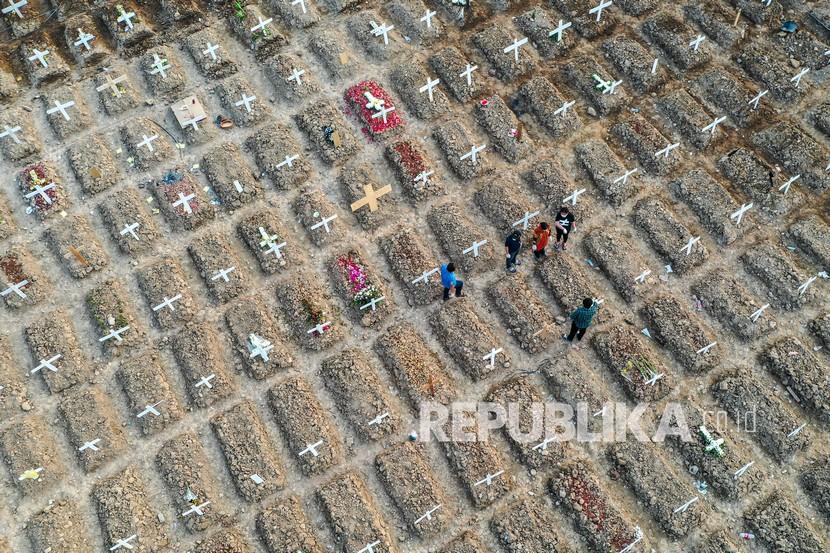 Foto udara warga berziarah di dekat pusara keluarganya di area pemakaman khusus COVID-19 di TPU Rorotan, Cilincing, Jakarta Utara, Kamis (15/7/2021). Berdasarkan data Worldometer, Indonesia resmi masuk empat besar kasus aktif COVID-19 terbanyak di seluruh dunia, pada Kamis (15/7/2021) kasus aktif di Indonesia mencapai 480.199 kasus, melampaui Rusia yang tercatat 457.250 kasus, Indonesia juga jauh melampaui India yang tercatat 432.011 kasus. 