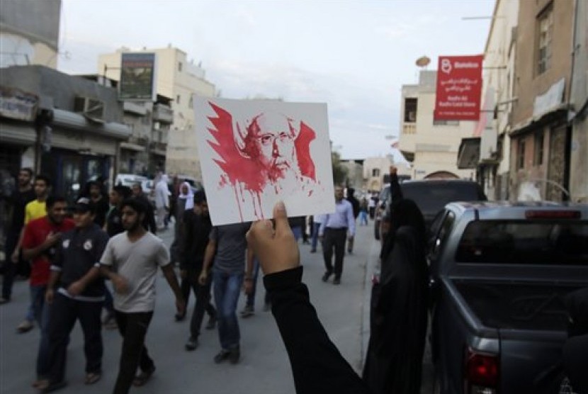 Foto ulama Syiah Nimr al-Nimr yang dieksekusi Arab Saudi diacungkan dalam unjuk rasa damai di Bahrain, Sabtu (2/1), memprotes tindakan yang dianggap semena-mena oleh Saudi.
