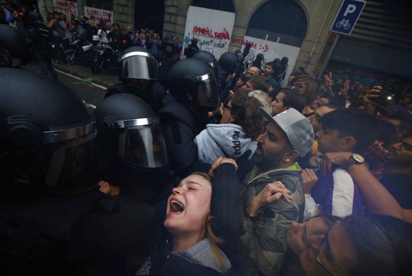  Foto yang diambil pada Minggu (1/10) memperlihatkan seorang gadis berteriak histeris kepada petugas Polisi Spanyol yang berusaha membubarkan para pendukung pro referendum kemerdekaan katalunya di luar gedung sekolah Ramon Llull di Barcelona.