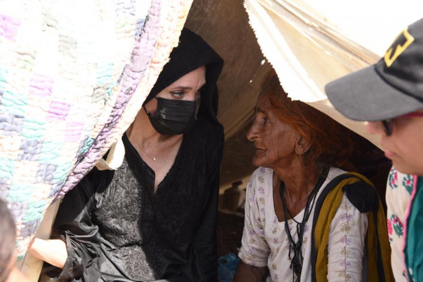 Foto yang dipasok oleh International Rescue Committee (IRC) memperlihatkan aktris dan aktivis asal AS, Angelina Jolie (kiri), berbicara dengan seorang perempuan korban banjir di kamp pengungsi di Dadu, Provinsi Sindh, Pakistan, 20 September 2022 (dirilis 21 September 2022).