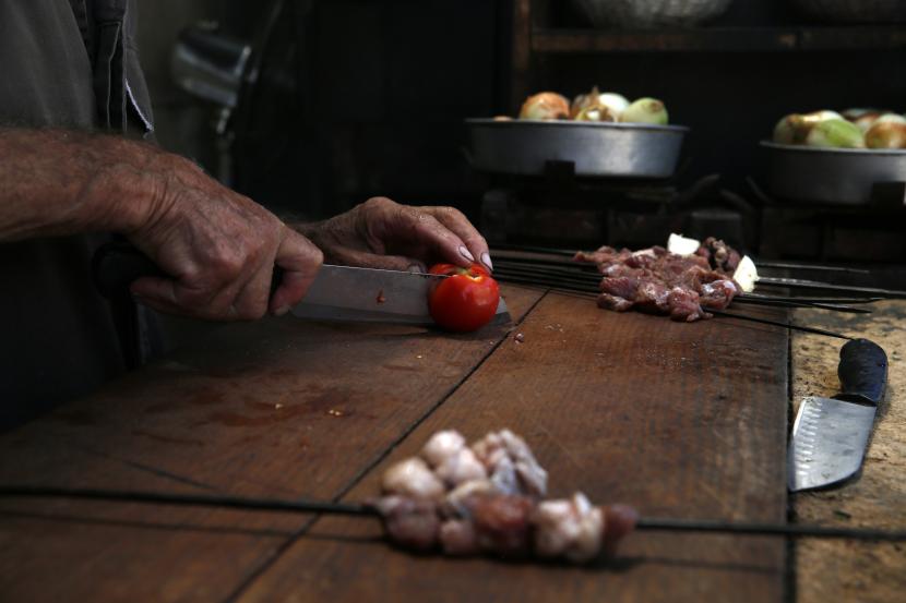 Fouad Abu Halawa, 86, bekerja di restorannya di Kota Tua Nablus, Tepi Barat, 14 Juni 2020. Koki Palestina Izzeldin Bukhari memulai tur yang ditawarkan ke Kota Tua Yerusalem dengan sarapan di restoran hummus Abu Shukri.