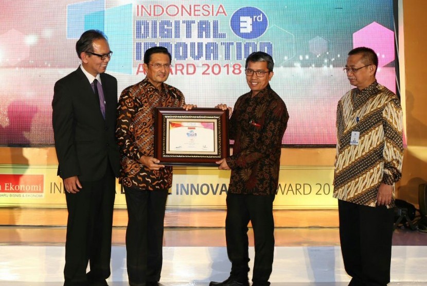 Founder and President Commissioner Warta Ekonomi Fadel Muhammad (kedua dari kiri) menyerahkan piagam Indonesia Digital Innovation Award 2018 kepada Direktur Jasa Keuangan PT Pos Indonesia (Persero) Ihwan Sutardianta (kedua dari kanan) di Balai Kartini, Jakarta, Jumat (25/5).