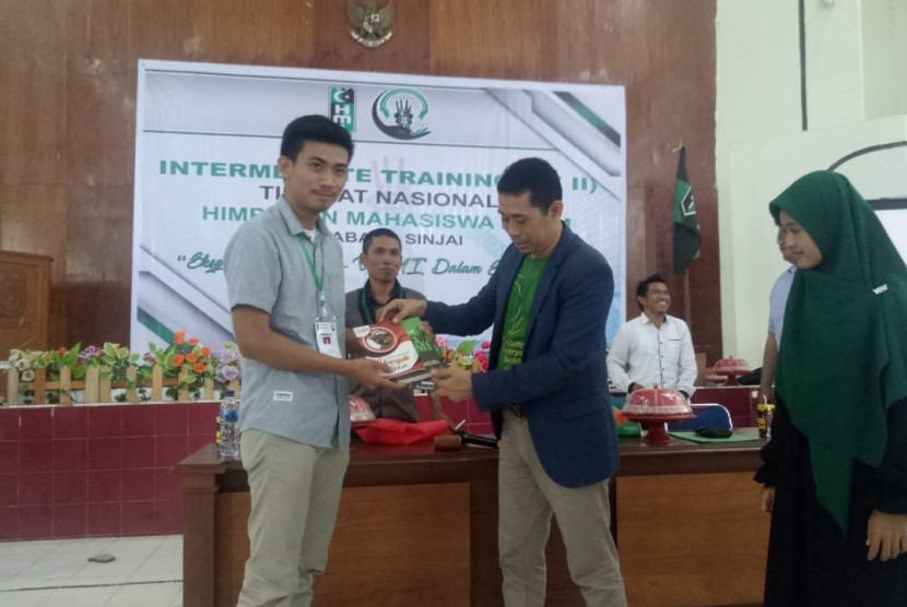 Founder KAHMIPreneur Kamrussamad menyerahkan cindramata kepada salah seorang perserta pada acara LK II HMI Sinjai, di Aula Kantor Badan Kepegawaian Daerah (BKD), Kabupaten Sinjai.