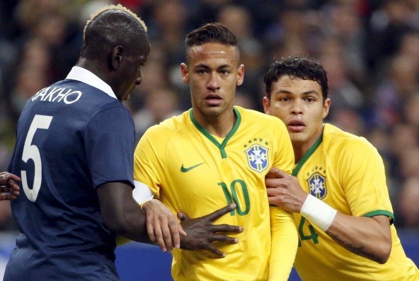 France's Mamadou Sakho (L) reacts next to Brazil's Neymar (C) and Thiago Silva (R) during their international friendly soccer match at the Stade de France, in Saint-Denis, near Paris, March 26, 2015.