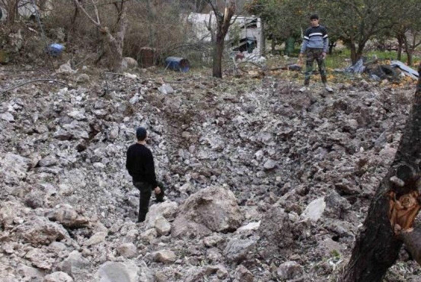 Free Syrian Army fighters inspect a crater caused by what activists said were barrel bombs dropped by government forces at the Jabal al-Akrad area in Syria's northwestern Latakia province January 23, 2014. 