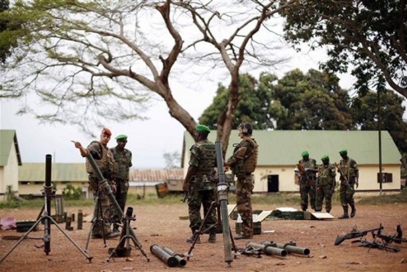 Tentara Prancis dan Rwanda memeriksa senjata yang ditinggalkan militan Seleka setelah mereka mengevakuasi kamp Kasai di Bangui, Republik Afrika Tengah.