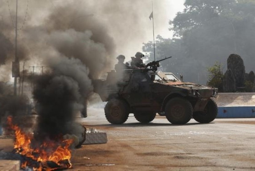 French troops secure an area after protesters from an angry mob set fire to the dead body of a Muslim man along a street in Bangui, January 19, 2014.