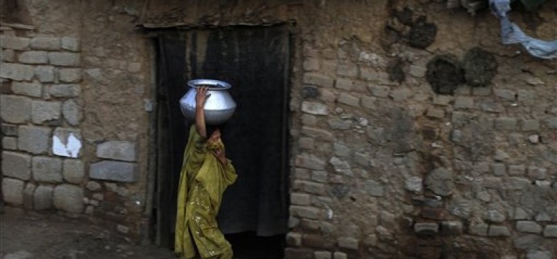 Gadis Pakistan yang mengungsi dari kawasan tribal yang dilanda pertempuran, tengah mengambil air dari sebuah sumur di kawasan kumuh Islamabad.