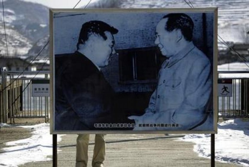 Gambar Mao Zedong (kanan) berjabat tangan dengan Kim Il Sung (kiri) berdiri di atas Jembatan Hekou yang menghubungkan Cina dan Korut. Jembatan tersebut dibom saat berlangsung Perang Korea (1950-1953)