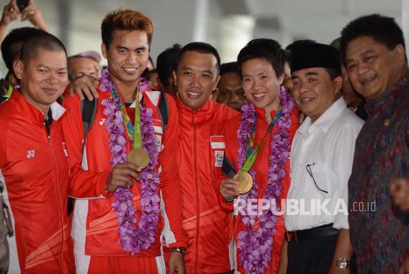 Ganda campuran bulutangkis peraih medali emas Olimpiade Brasil, Tontowi Ahmad (kedua kiri) dan Liliyana Natsir (ketiga kanan) disambut oleh Menpora Imam Nahrawi (tengah) dan Ketua DPR Ade Komaruddin (kedua kanan) saat tiba di Terminal 3 baru Bandara Soekar