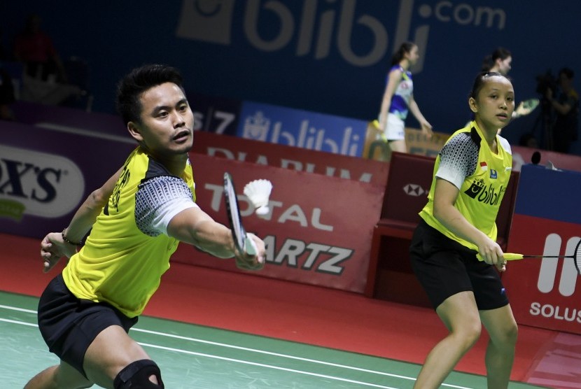 Ganda campuran Indonesia Tontowi Ahmad (kiri) dan Winny Oktavina Kandow (kanan) mengembalikan kok kepada ganda campuran Malaysia Chan Peng Soon dan Goh Liu Ying pada babak perempat final Blibli Indonesia Open 2019 di Istora Senayan, Jakarta, Jumat (190/7/2019). 