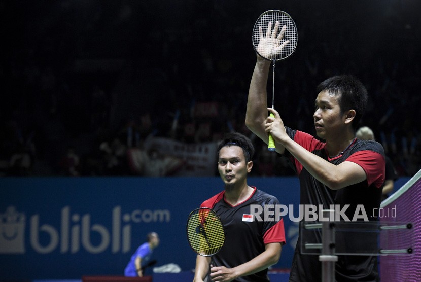 Ganda putra Indonesia Hendra Setiawan (kanan) dan Mohammad Ahsan (kiri) menyapa suporter seusai bertanding melawan ganda putra Inggris Marcus Ellis dan Chris Langridge pada babak pertama Blibli Indonesia Open 2019 di Istora Senayan, Jakarta, Rabu (17/7/2019). 