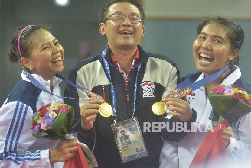Ganda putri Indonesia Nitya Krishinda (kanan) dan Gresya Polii (kiri) bergembira bersama pelatih mereka Eng Hian (tengah) usai penghargaan medali Asian Games ke-17 di Gyeyang Gymnasium, Incheon, Korsel, 27 September 2014.