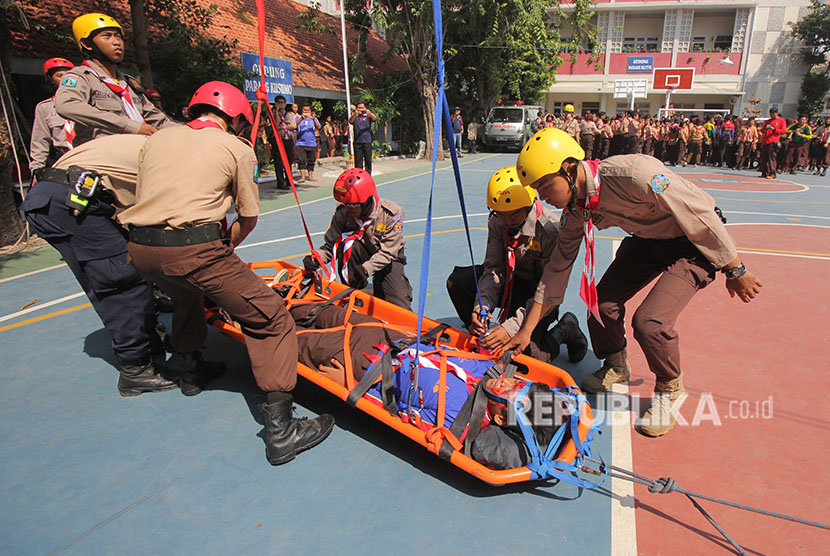 Garda Penolong Pramuka menandu korban gempa saat simulasi tanggap bencana di SDN Kapasari VIII, Surabaya, Jawa Timur, Sabtu (28/4).