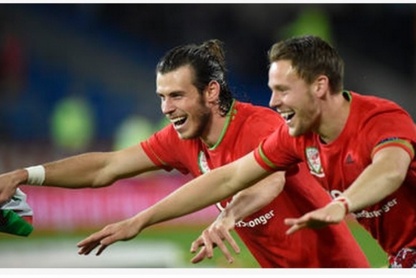 Gareth Bale (kiri) merayakan keberhasilan Wales mengalahkan Andorra bersama rekannya.