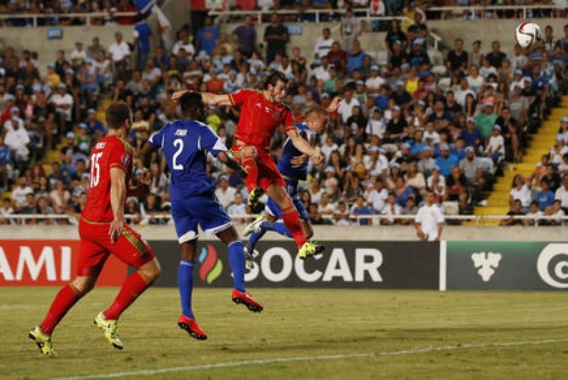 Gareth Bale (melompat berbaju merah) mencetak gol untuk Wales ke gawang Siprus dalam laga kualifikasi Piala Eropa 2016.