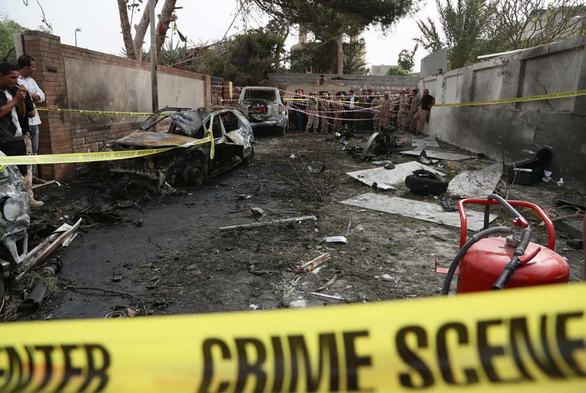  Garis polisi melingkari tempat kejadian ledakan sebuah bom mobil yang menargetkan Kedubes Perancis  di Tripoli, Libya, Selasa (23/4).      (AP/Abdul Majeed Forjani)