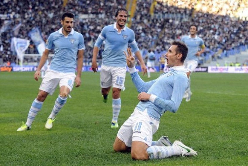 Gaya striker Lazio Miroslav Klose usai mencetak gol ke gawang Parma, Ahad (2/12) malam. Lazio menang 2-1 pada pertandingan yang berlangsung di Stadion Olimpico Roma itu.