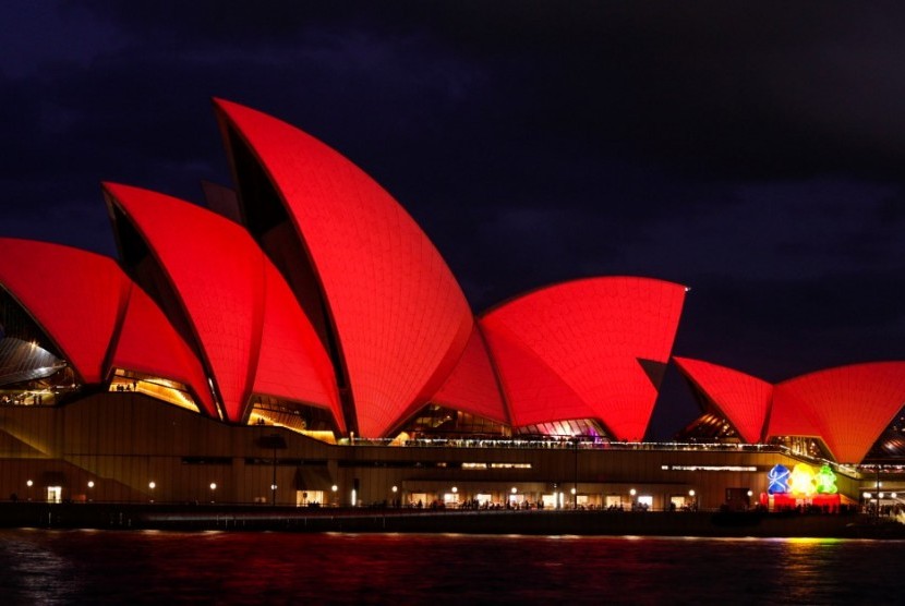 Gedung Opera House bermandikan cahaya merah.