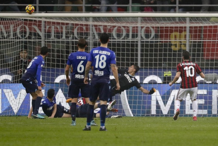 Gelandang AC Milan Hakan Calhanoglu (kanan) menyaksikan bola percobaannya ke gawang Lazio hanya melambung setelah mengenai mistar dalam pertandingan leg pertama Coppa Italia di San Siro, Milan, Kamis (1/2) dini hari WIB.