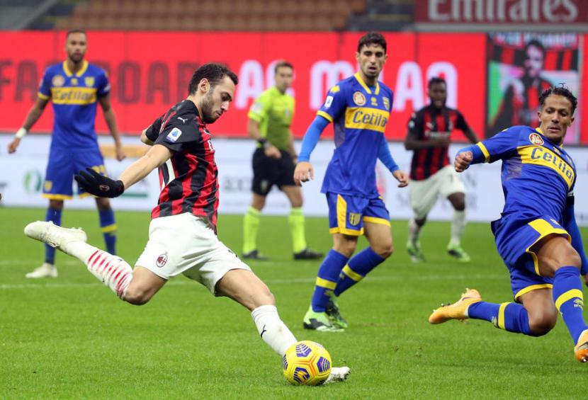  Gelandang AC Milan, Hakan Calhanoglu (kiri) menendang bola pada laga Serie A melawan Parma, Senin (14/12) dini hari WIB. Laga berakhir imbang 2-2.
