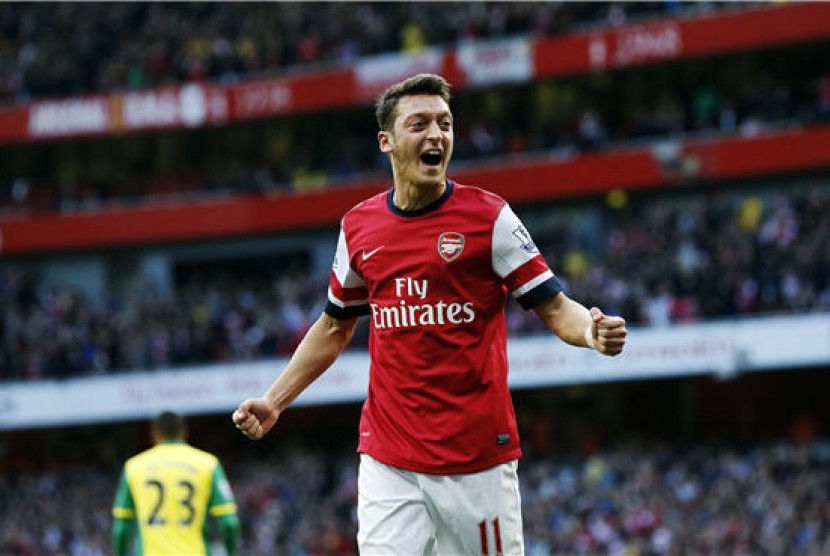 Gelandang Arsenal, Mesut Ozil, melakukan selebrasi usai menjebol gawang Norwich City di laga Liga Primer Inggris di Stadion Emirates, London, Sabtu (19/10). 