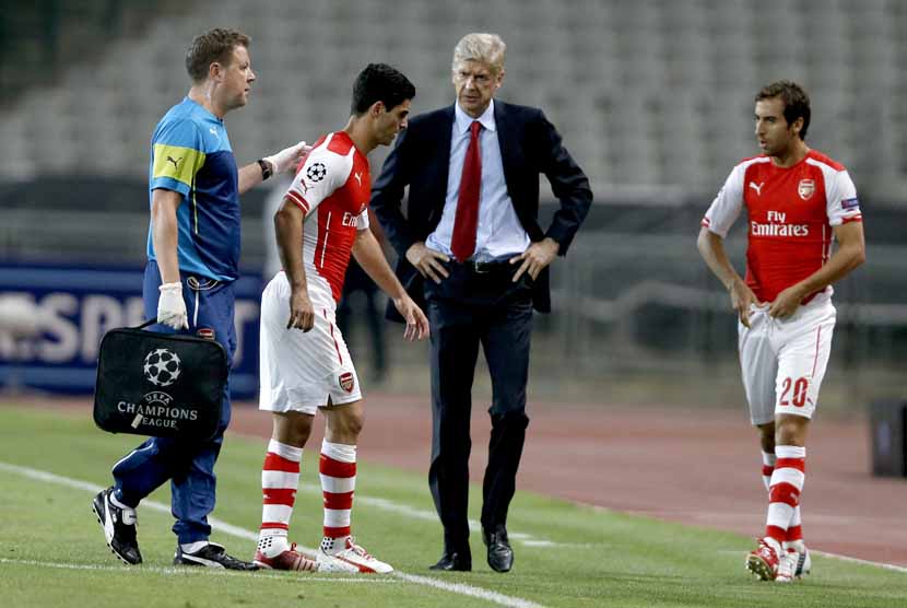 Gelandang Arsenal, Mikel Arteta (dua kiri), ditarik keluar lantaran mengalami cedera saat menghadapi Besiktas di leg pertama babak playoff Liga Champions di Istanbul, Turki, Selasa (19/8). 