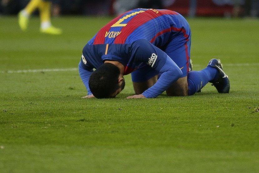 Gelandang Barcelona, Arda Turan bersujud syukur seusai menjebol gawang Las Palmas pada laga La Liga di Camp Nou, Sabtu (14/1). Barcelona menang 5-0 pada laga ini.