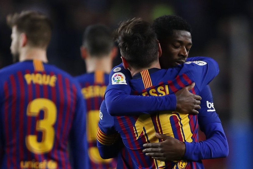 Gelandang Barcelona, Ousmane Dembele (kanan) merayakan gol dengan berpelukan dengan Lionel Messi pada laga Liga lawan Celta Vigo, Ahad (23/12) dini hari WIB.