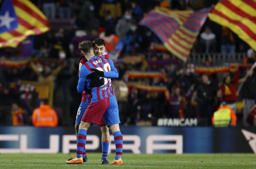 Gelandang Barcelona, Pedri (kanan) berpelukan dengan Gavi merayakan gol ke gawang Sevilla pada laga La Liga di Camp Nou, beberapa waktu lalu.