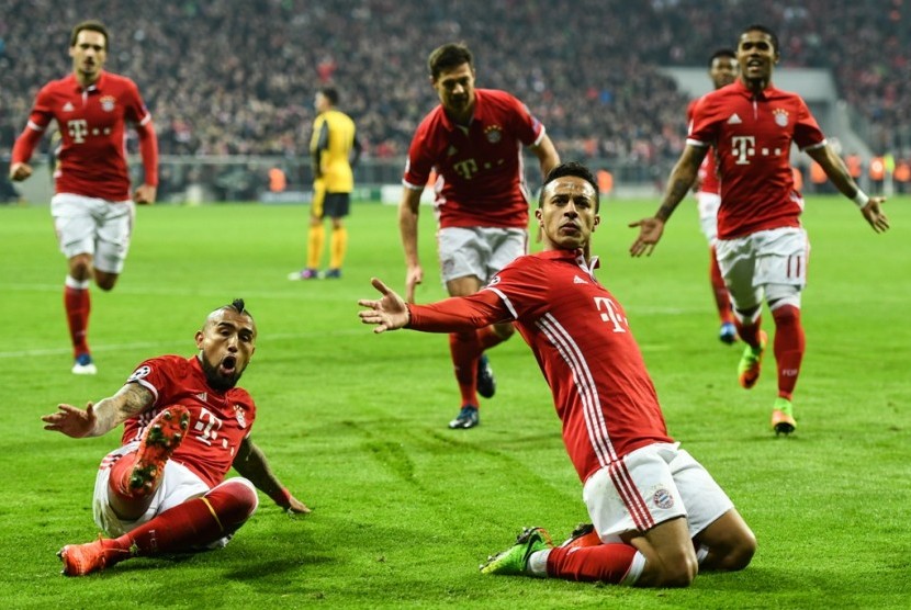 Gelandang Bayern Muenchen Thiago (kanan bawah) merayakan golnya ke gawang Arsenal bersama rekan-rekannya. Thiago mencetak dua gol dalam kemenangan besar Muenchen 5-1, Rabu (16/2). Malam ini mereka berpeluang mengunci gelar Bundesliga.